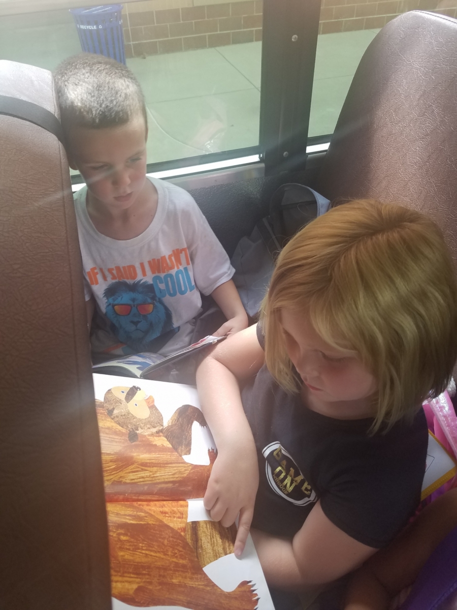 Students reading a book on the bus